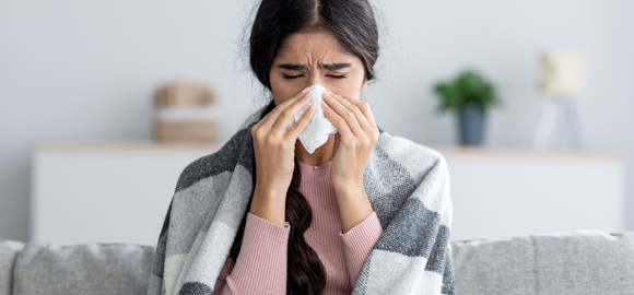 Young-Woman-Suffering-from-Viral-Infection-Blowing-Running-Nose-in-a-Tissue-Paper